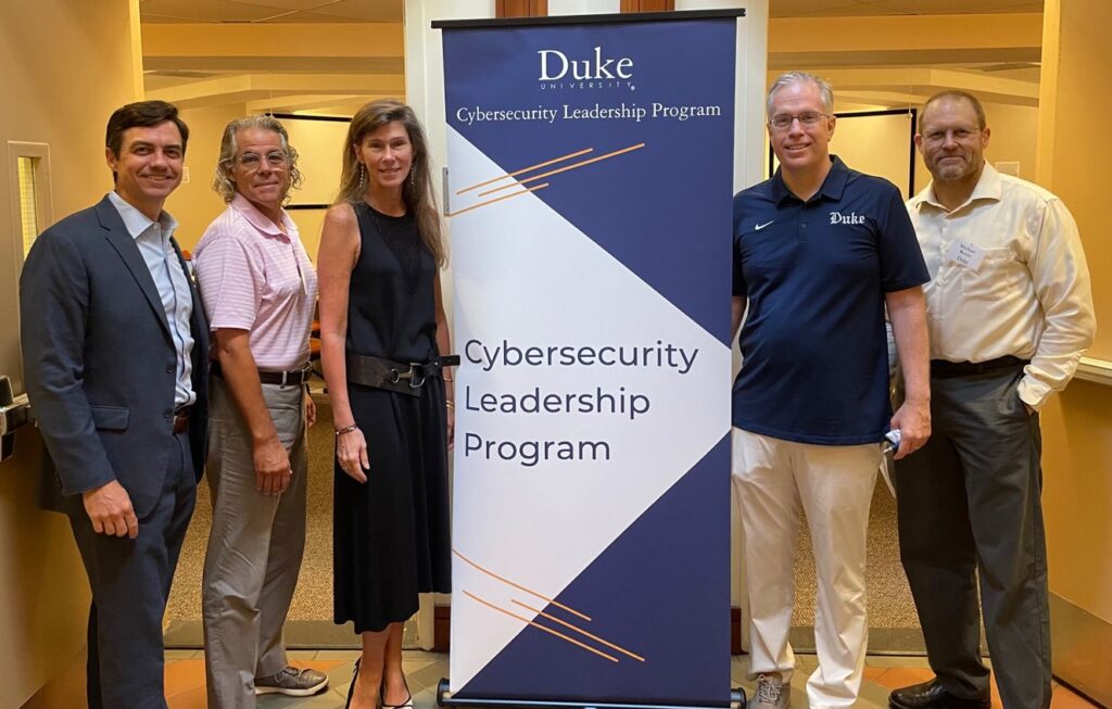 Duke University Cybersecurity Leadership Program Faculty pose in front of classroom with sign.